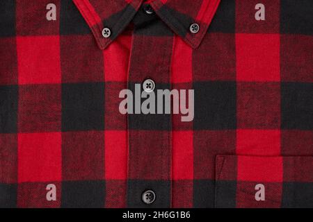 Detailed photograph of a men's flannel shirt in a tartan pattern, showing a portion of the collar and pocket with the centerline and buttons Stock Photo