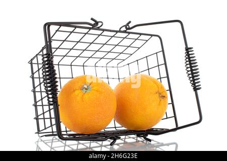 Two organic bright yellow oranges with a basket, close-up, isolated on white. Stock Photo