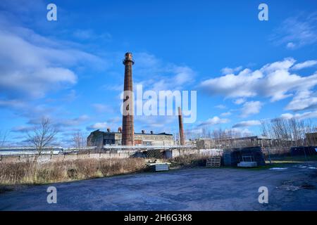 Old factory under the blue sky. Industrial building with chimney made of red brick. High quality photo Stock Photo