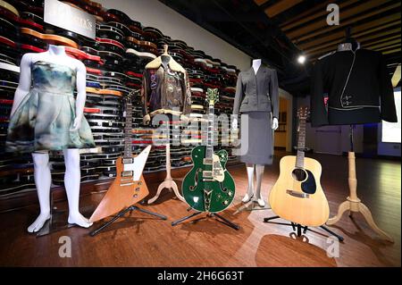 New York, USA. 15th Nov, 2021. (L-R) A Katy Perry dress, U2's Edge guitar, a WWII bomber jacket gifted to Michael Jackson, U2's Bono electric guitar, Madona's “Evita” dress, Jim Croce's acoustic guitar and a Michael Jackson jacket on display during Julien's Auction Icons & Rock “N” Roll press preview at the Times Square Hard Rock in New York NY, November 15, 2021. (Photo by Anthony Behar/Sipa USA) Credit: Sipa USA/Alamy Live News Stock Photo