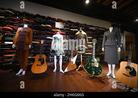 New York, USA. 15th Nov, 2021. (L-R) A Whitney Houston dress, Eric Clapton's “Derek and The Dominos” 1968 Martin D-45 acoustic guitar, a Katy Perry dress, U2's Edge guitar, a WWII bomber jacket gifted to Michael Jackson, U2's Bono electric guitar, Madona's “Evita” dress and Jim Croce's acoustic guitar on display during Julien's Auction Icons & Rock “N” Roll press preview at the Times Square Hard Rock in New York NY, November 15, 2021. (Photo by Anthony Behar/Sipa USA) Credit: Sipa USA/Alamy Live News Stock Photo