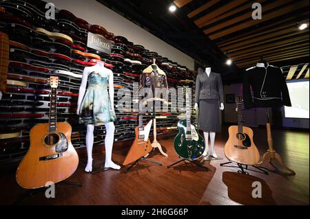 New York, USA. 15th Nov, 2021. (L-R) Eric Clapton's “Derek and The Dominos” 1968 Martin D-45 acoustic guitar, a Katy Perry dress, U2's Edge guitar, a WWII bomber jacket gifted to Michael Jackson, U2's Bono electric guitar, Madona's “Evita” dress, Jim Croce's acoustic guitar and a Michael Jackson jacket on display during Julien's Auction Icons & Rock “N” Roll press preview at the Times Square Hard Rock in New York NY, November 15, 2021. (Photo by Anthony Behar/Sipa USA) Credit: Sipa USA/Alamy Live News Stock Photo