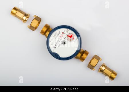 Disassembled water meter with details for measures the quantity and volume of water that passes through a pipe. Plumbing tool equipment on white Stock Photo