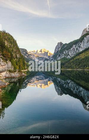 Beautiful view of idyllic colorful autumn scenery with Dachstein mountain summit reflecting in crystal clear Gosausee mountain lake in fall Stock Photo