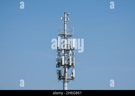 Cell phone, mobile phone telecommunication tower with antennas on blue sky Stock Photo
