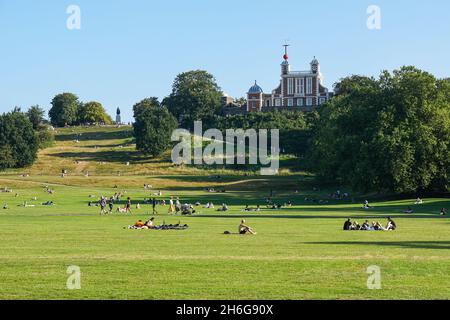 People enjoying sunny day in Greenwich Park with the Royal Observatory in the background, London, England, United Kingdom, UK Stock Photo