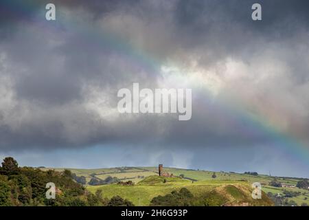 Redbay Castle under a rainbow at Waterfoot Beach , Co. Antrim, Northern Ireland Stock Photo