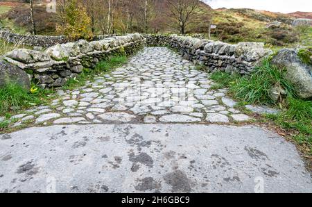 Stone footbridge over Watendlath Beck at Watendlath Tarn in the Lake District in Cumbria, England Stock Photo