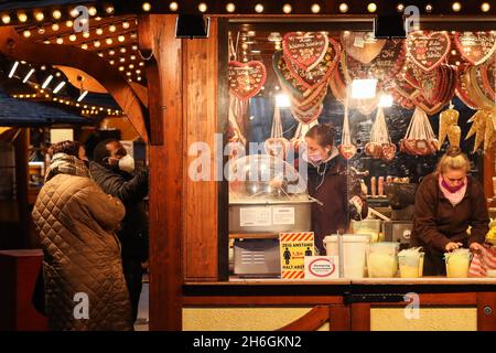 Berlin, Germany. 15th Nov, 2021. A confectioner of a sweet shop makes cotton candy at a market in Berlin, Germany, on Nov. 15, 2021. Due to rapid increase of new COVID-19 cases, Berlin on Monday started to tighten COVID-19 measures. Germany's seven-day incidence rate hit a new all-time high and reached 303.0 per 100,000 inhabitants, the Robert Koch Institute (RKI) for infectious diseases announced on Monday. Credit: Shan Yuqi/Xinhua/Alamy Live News Stock Photo