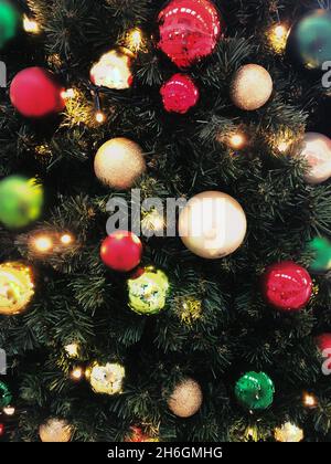 Full frame festive background of colourful Christmas baubles hanging on an artificial Christmas tree with copy space Stock Photo