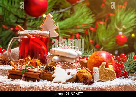 Christmas celebration concept with cup of mulled wine, Christmas cookies, fruit and spices, closeup with selective focus on the background of the Chri Stock Photo