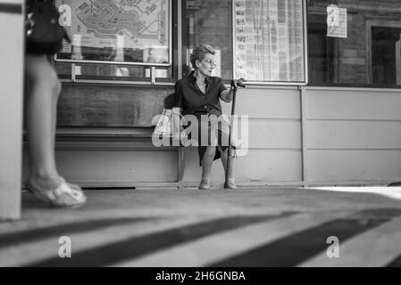 Elderly woman with a cane waits for the vaporetto to arrive Stock Photo