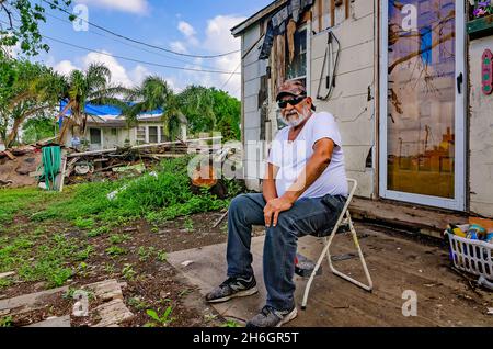 Joe Guerra sits in front of his storm-damaged house as he waits for his daughter after Hurricane Harvey, Oct. 4, 2017, in Refugio, Texas. Stock Photo