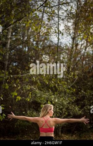 Back view of strong woman in 30's with outstretched arms Stock Photo