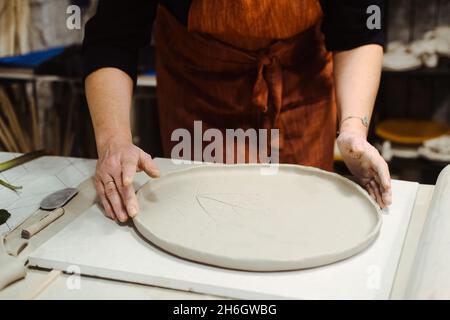 Women's hands work with clay on the table Stock Photo