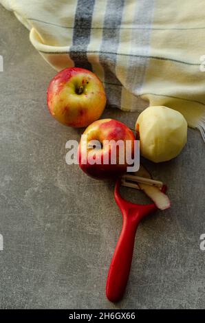 peeling red ripe apples for pie Stock Photo