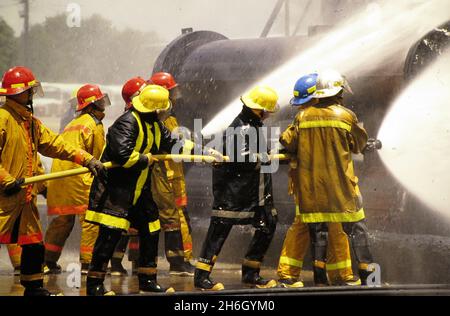 College Station Texas USA, circa 1988: Industrial firefighters control chemical fires at Fire Training School at Texas A&M University, ©Bob Daemmrich Stock Photo