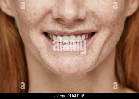 Close up shot of red haired woman with freckles smiling at camera, focus on white teeth, copy space Stock Photo