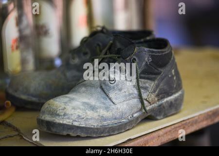 Old Boots, black shoes dirty on the shoe rack, military boots Stock Photo