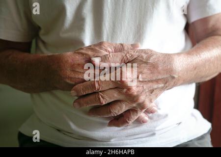 Close up view of senior man's hands clasped together. Stock Photo