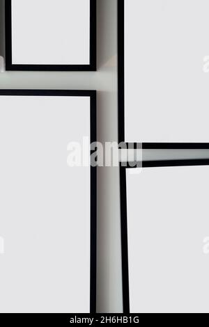 Different size framed photos hanging on the gray wall. Mockup. Stock Photo