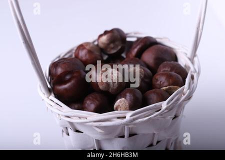 Chestnuts in the basket, white background Stock Photo