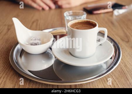 Traditional Turkish coffee with cold water and Turkish delight in cafe. Selective focus - Image Stock Photo