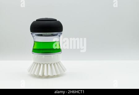 Dish brush cleaning tool with green liquid detergent isolated on white background. Stock Photo