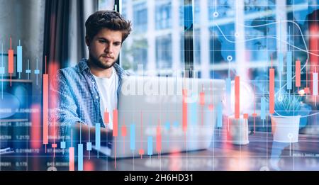 Young man working at modern office.Technical price graph and indicator, red and green candlestick chart and stock trading computer screen background. Stock Photo