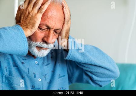 Depressed senior man patient suffering from headache and illness in hospital. Healthcare concept Stock Photo