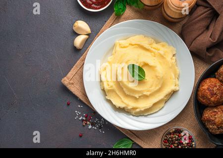 Mashed potatoes garnish for dinner on a dark background. Top view, copy space. Stock Photo