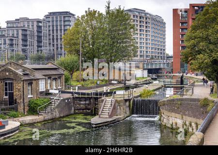 Pedestrians and cyclists travel along the Regent's Canal towpath at St Pancras Lock, beside Gasholders Park, Kings Cross, London. Stock Photo