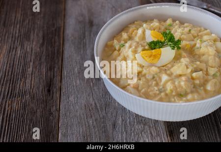 A bowl with fresh and homemade egg salad isolated on wooden table background Stock Photo