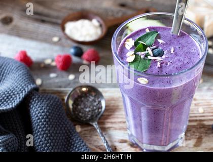 Healthy breakfast smoothie with fresh berries, whey protein, chia seeds, almonds and oat flakes Stock Photo