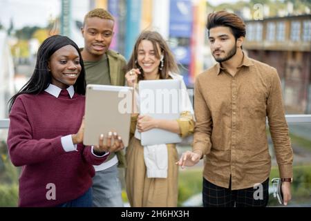 Multiracial students watch some on digital tablet Stock Photo