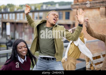 Students celebrate on balcony at university campus Stock Photo