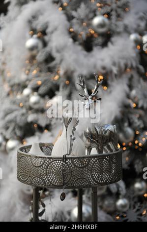 Christmas decoration in interior. A silver deer and a Christmas tree in a background Stock Photo