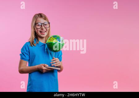 Schoolgirl holding her scientific project DIY cell model on pink background with blank space for text Stock Photo