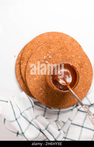 Homemade salted caramel in a glass jar. Delicious sauce with sea salt for ice cream and desserts. Stock Photo