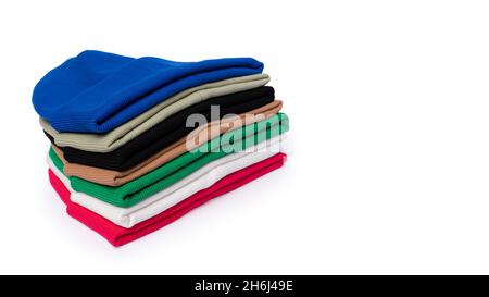 Stack of insulated stylish beanie hats in bright colors isolated on white with copy space. Stock Photo