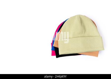 Top view of stack of insulated stylish beanie hats in different colors isolated on white background with copy cpace Stock Photo