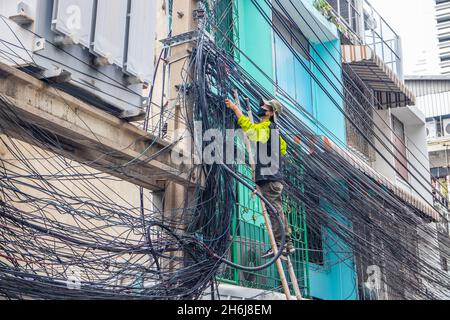BANGKOK, THAILAND - Oct 18, 2021: An electrician doing his daily work in Bangkok, Thailand, Southeast Asia Stock Photo
