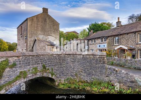 Bridge over Peakshole Water, a stream flowing through the picturesque village of Castleton to join the River Noe, in the Peak District. Derbyshire. Stock Photo