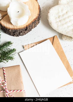 Winter composition of knitted mittens, envelope and paper card, candles and present on white background. Top view. Flat lay. copy space Stock Photo