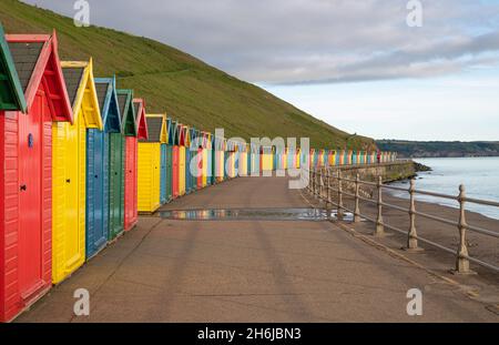 Row of colourful wooden beach huts along the promenade at Whitby Stock Photo