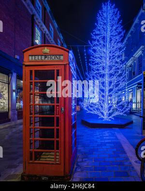 A red telephone box, and blue christmas decorations on South Molton Street in Mayfair, London. Stock Photo