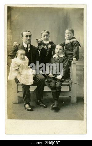 Original early 1900's Edwardian postcard of father with his children, boys in sailor suits, whip, baby, Yorkshire terrier, Mr James Heppell, son from studio of Joe Gardner West Cornforth Co. Durham, circa 1910 Stock Photo