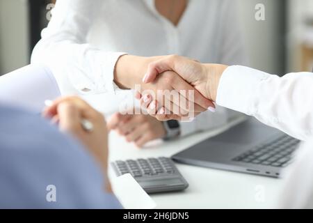 Focus on women shaking hands after signing profitable bargain Stock Photo