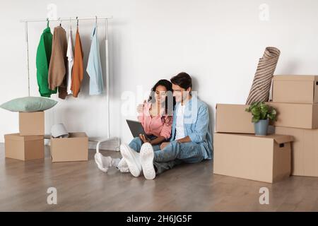 Happy couple using digital tablet after relocation Stock Photo