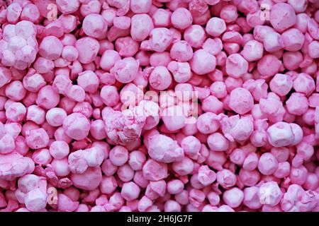 Polystyrene balls colored in pink, forming a background texture that looks like colored stones. Stock Photo